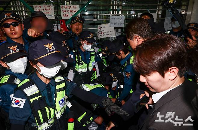 6·3 지방선거 투표용지 부족 사태를 조사 중인 국회 국정조사특별위원회 위원들이 2일 서울 송파구 올림픽공원 내 개표소를 찾은 가운데 출입문을 가로막은 시위 참가자가 경찰에 연행되고 있다. 국회사진기자단
