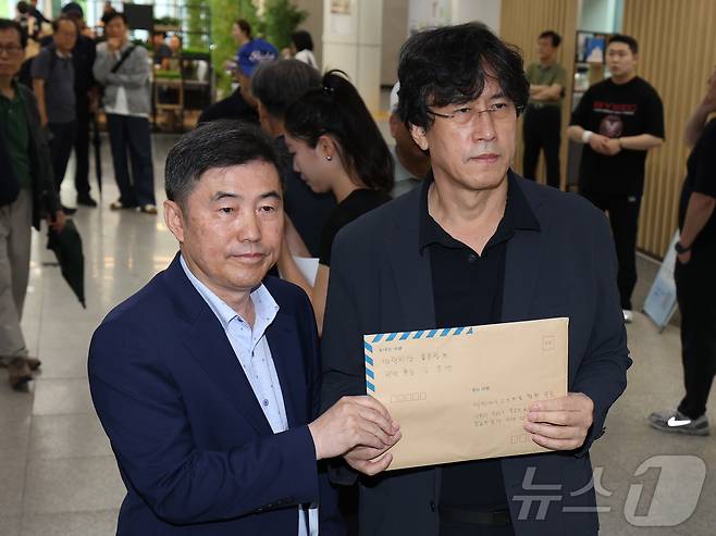 김동연 배재학당 총동창회장(오른쪽)이 3일 서울 송파구 올림픽회관에서 배재고 야구부의 5·18 민주화운동 폄훼 논란과 관련해 대한야구소프트볼협회에 제출할 대국민 탄원서를 들어 보이고 있다. ⓒ 뉴스1 이종수 기자