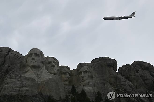 미국 전직 대통령의 두상이 새겨진 러시모어산 위를 비행하는 트럼프 전용기 [AP=연합뉴스. 재판매 및 DB 금지]