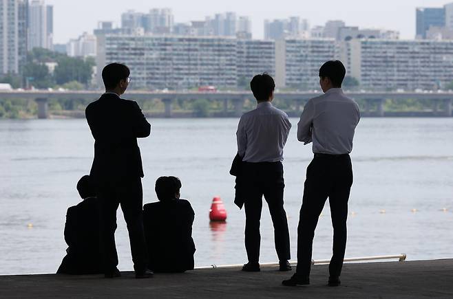 지난달 서울 영등포구 여의도한강공원에서 직장인들이 그늘에 앉아 휴식을 취하고 있다. 연합뉴스
