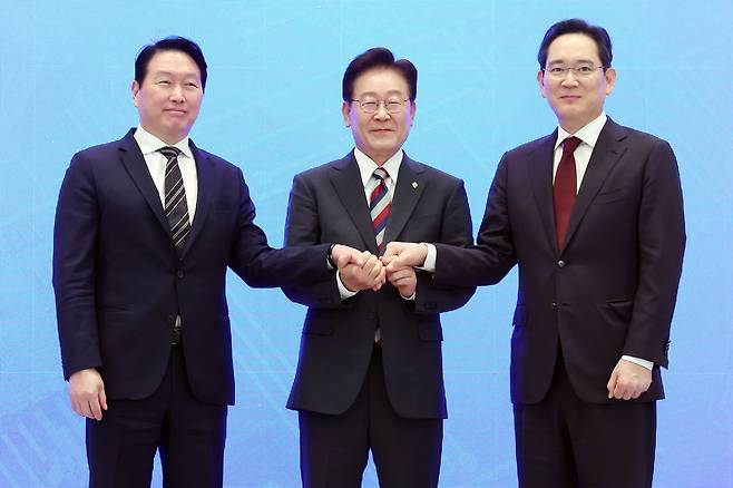 이재명 대통령과 이재용 삼성전자 회장, 최태원 SK그룹 회장이 지난 29일 청와대에서 열린 3대 메가프로젝트 국민보고회에서 기업 투자계획 발표 후 손을 잡고 있다. [연합]