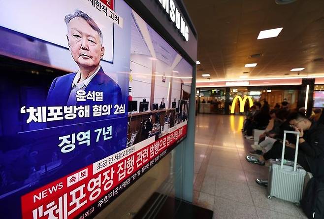 29일 오후 서울 중구 서울역 대합실에서 시민들이 체포 방해 및 국무위원 심의권 침해 혐의로 기소된 윤석열 전 대통령에 대한 2심 선고 공판 생중계를 보고 있다. 2026.04.29.ⓒ뉴시스