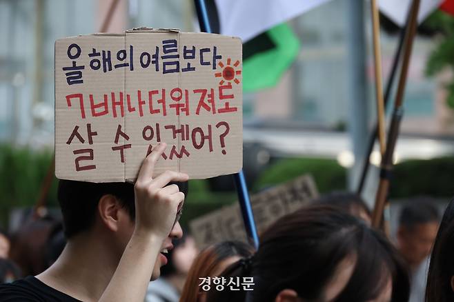 지난해 9월27일 ‘9.27 기후정의행진’ 참가자가 더워지는 여름과 관련한 손팻말을 들고 서울 종로구 광화문 동십자각에서 종각역과 시청광장 등을 거쳐 돌아오는 행진을 하고 있다. 한수빈 기자