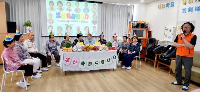 함영덕(오른쪽) 늘푸른기억학교 원장이 어르신 생신 축하 잔치를 진행하고 있다.