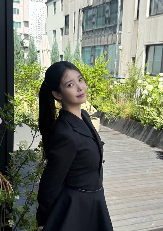 Singer and actress IU shared an official update on her activities for the first time in about two months by attending the handprinting ceremony for the 5th Blue Dragon Series Awards. IU appeared in a neat and polished look, wearing a black mini-jacket dress, delighting her fans.On the 7th, IU attended the handprinting event held at CGV Yongsan IPark Mall in Yongsan-gu, Seoul, where she posed for photos and shared a selfie. IU drew attention with her ponytail hairstyle and stylish outfit, and she sent a message of encouragement to her fans through her official account.This event drew particular attention as it marked IUs first public appearance in about two months following the controversy that arose last May. At the time, IU had posted an apology regarding the drama-related controversy.Fans expressed their delight at hearing from IU after such a long time and sent her enthusiastic support. They left comments on IUs social media posts, showing their unwavering affection and support.