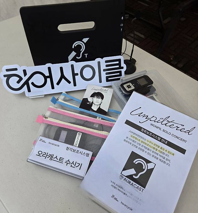 JYP와 히어사이클이 진행하는 ‘청각 접근성 개선 프로젝트’에서 난청인 관객들에게 지급되는 수신기와 안내문. [사진 JYP엔터테인먼트]