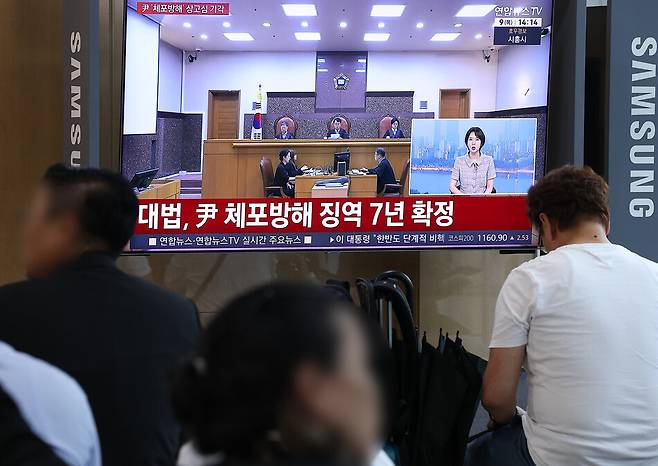 윤석열 전 대통령의 고위공직자범죄수사처(공수처) 체포방해 등 혐의 사건 상고심 선고기일인 9일 서울역에서 시민들이 관련 방송을 지켜보고 있다.