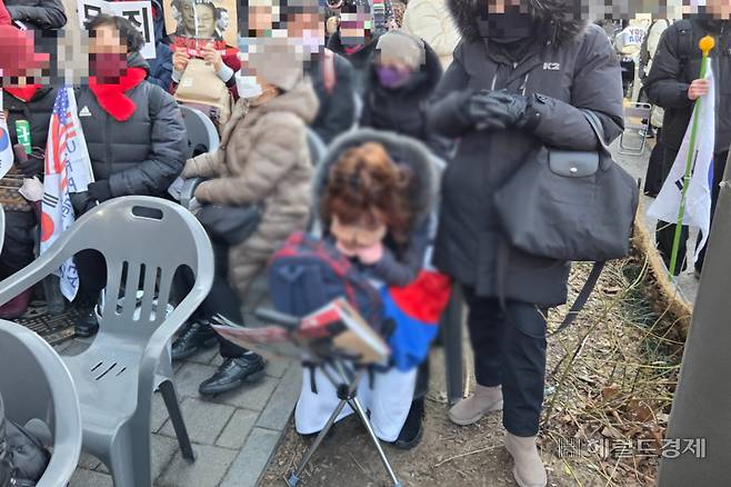 19일 오후 3시께 서울 서초구 서울중앙지방법원 앞 도로에서 열린 윤석열 전 대통령 지지 집회에서 무기징역 선고 결과를 듣자 한 지지자가 얼굴을 감싸고 울고 있다. 이영기 기자.
