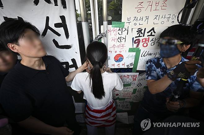 잠실 핸드볼경기장 진입 저지하는 시위 참가자 (서울=연합뉴스) 서대연 기자 = 6·3 지방선거 투표용지 부족 사태로 시작한 서울 송파구 올림픽공원 핸드볼경기장 일대 '개표소 봉쇄 시위'가 이어지는 가운데 16일 한 시위 참가자가 대한체육회 등 입주 단체 관계자들의 진입을 막아서고 있다. 2026.6.16 [공동취재] dwise@yna.co.kr
