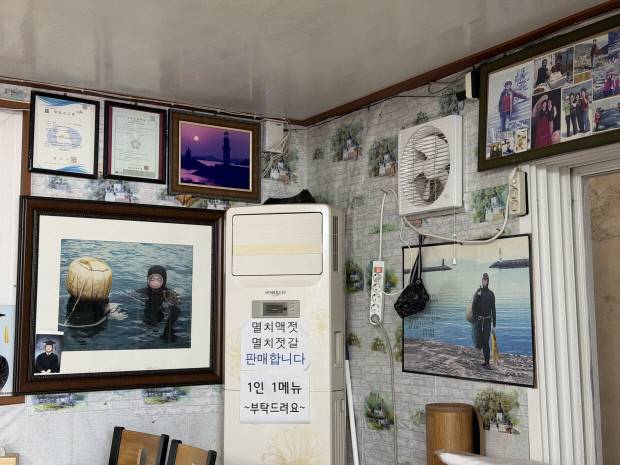 ‘해녀식당’ 내부를 가득 채운 오 씨의 해녀 시절 사진들.