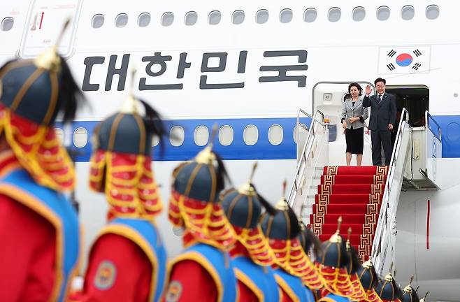 몽골 국빈 방문 공식일정을 마치고 귀국하는 이재명 대통령과 김혜경 여사가 11일(현지시간) 칭기스칸 국제공항 한국행 공군 1호기에서 환송객에게 인사하고 있다. 뉴스1