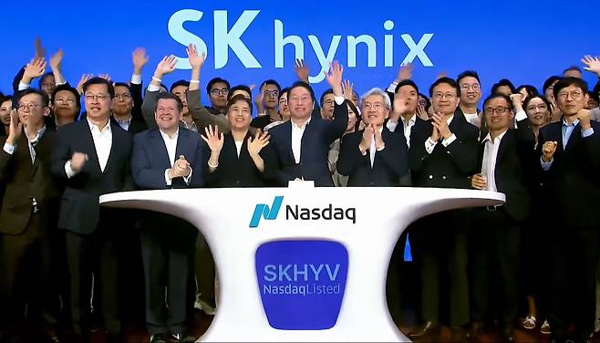 최태원(앞줄 가운데) SK그룹 회장과 곽노정 SK하이닉스 대표 등 관계자들이 10일(현지 시간) 미국 뉴욕 타임스스퀘어 나스닥 마켓사이트에서 열린 SK하이닉스 미국주식예탁증서(ADR) 상장 기념 ‘오프닝벨’ 행사에서 손을 흔들며 환호하고 있다. 사진 제공=SK하이닉스 유튜브 캡처