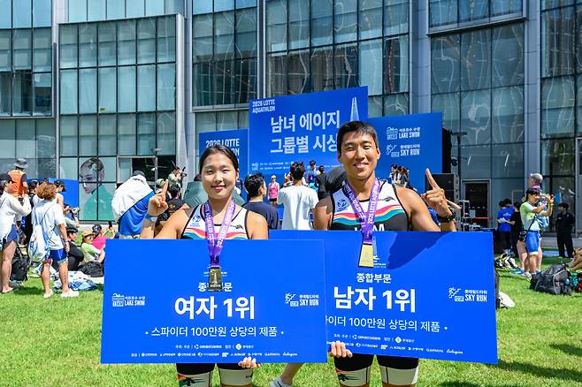 여성 1위 김태향 씨, 남성 1위 김완혁 씨가 2023 롯데 아쿠아슬론 대회에서 기념사진을 촬영하고 있다.(사진제공=롯데물산)