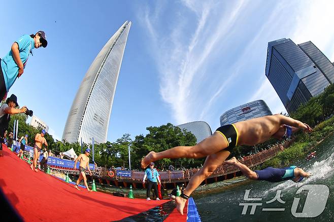 12일 오전 서울 송파구 석촌호수와 롯데월드타워 일원에서 열린 '2026 롯데 아쿠아슬론'에서 참가자들이 힘차게 출발하고 있다. (공동취재) 2026.7.12 ⓒ 뉴스1 구윤성 기자