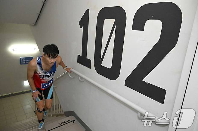 12일 오전 서울 송파구 석촌호수와 롯데월드타워 일원에서 열린 '2026 롯데 아쿠아슬론'에서 참가자가 123층 결승선을 향하고 있다.(공동취재) 2026.7.12 ⓒ 뉴스1 구윤성 기자