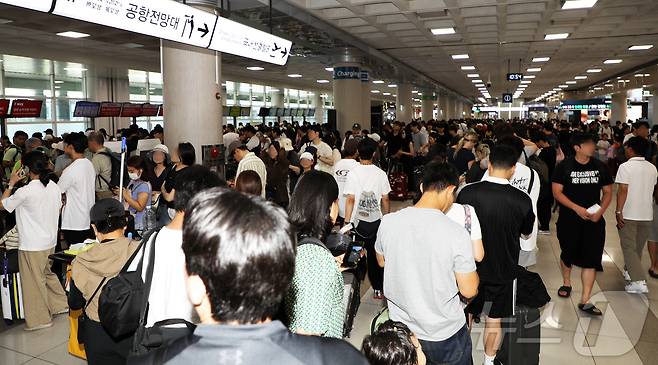 제주국제공항에 강풍 경보와 급변풍 경보가 내려진 11일 오전 제주국제공항 3층 국내선 출발 대합실에 결항 대체 항공편 탑승권을 구하려는 승객들이 긴 줄을 서고 있다. 2026.7.12 ⓒ 뉴스1 오미란 기자