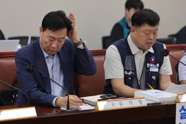 14일 정부세종청사 최저임금위원회에서 열린 제14차 전원회의에서 사용자위원인 류기정 한국경영자총협회(경총) 전무가 근로자위원인 류기섭 한국노총 사무총장의 발언을 들으며 머리를 매만지고 있다. 연합뉴스