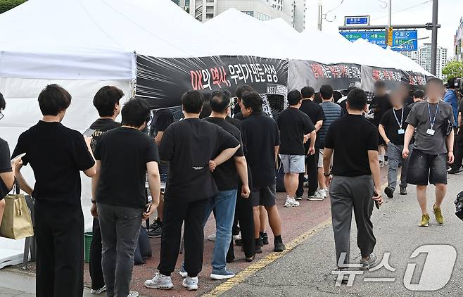14일 경기 수원시 영통구 삼성전자 수원사업장 중앙문에서 열린 'DX부문 사기진작 및 보상마련 촉구 집회'에서 조합원들이 '2026 DX부문 사망선고 위로를 위한 조문 행사'에 참여하고 있다. (공동취재) 2026.7.14 ⓒ 뉴스1 김영운 기자