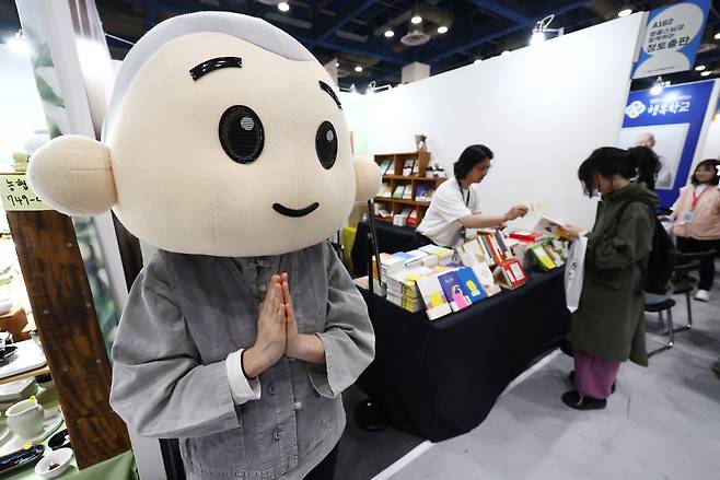A life-size mascot of a monk welcomes visitors at the 2026 Seoul International Buddhism Expo held in southern Seoul on April 2. NEWS1