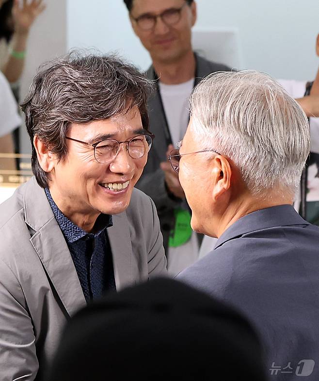 유시민 작가가 25일 서울 강남구 코엑스에서 열린 서울국제도서전 ‘돌베개·평산책방’ 부스를 찾아 문재인 전 대통령(오른쪽)과 인사를 나누고 있다. 2026.6.25 ⓒ 뉴스1 김진환 기자