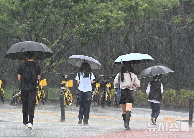 [수원=뉴시스] 김종택 기자 = 전국 곳곳에 호우특보가 발효된 지난 9일 경기 수원시 영통구 영통동에서 우산을 쓴 시민들이 횡단보도를 건너고 있다. 2026.07.09. jtk@newsis.com
