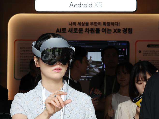 14일 서울 중구 신라호텔에서 열린 '구글 AI 포 비즈니스 2026' 전시장에서 관계자가 확장현실 헤드셋 갤럭시 XR로 미디어아트를 관람하고 있다. 연합뉴스