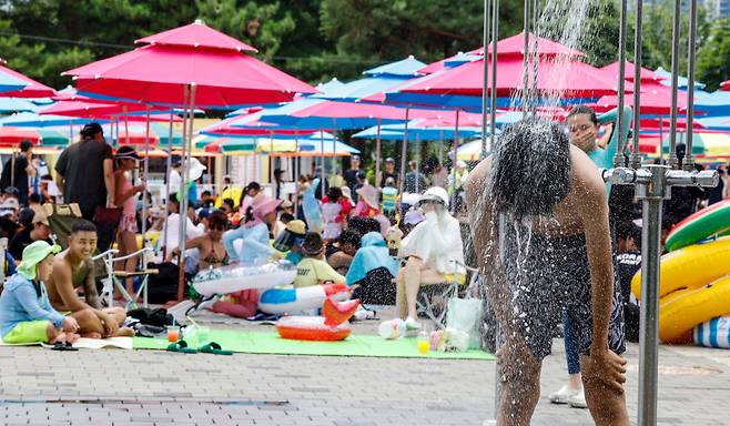 무더위가 이어진 19일 서울 광진구 뚝섬한강공원 수영장에서 한 시민이 샤워를 하고 있다.