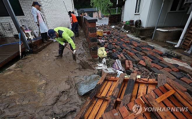 폭우에 쑥대밭 된 마을 (안동=연합뉴스) 윤관식 기자 = 19일 경북 안동시 일직면 귀미1리 한 주택에서 자원봉사자가 폭우로 인한 토사를 치우고 있다. 2026.7.19 psik@yna.co.kr
