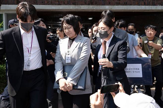 김지연 서울동부지방법원 부장판사와 관계자들이 지난달 10일 오후 6·3 지방선거 투표용지 부족 사태가 발생한 잠실7동 제2투표소였던 서울 송파구 우성아파트 노인정의 현장 검증을 마친 뒤 증거물을 들고 현장을 나서고 있다. 장진영 기자