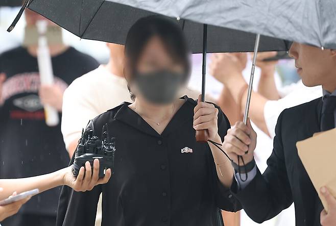 6·3 지방선거 개표소로 사용된 올림픽공원 핸드볼경기장 문 앞에서 체육단체 직원들의 장내 사무실 진입을 막아 업무 방해 혐의를 받는 30대 여성이 21일 구속 전 피의자 심문(영장실질심사)를 위해 서울 송파구 서울동부지방법원으로 출석하고 있다. 연합뉴스