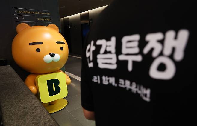 민주노총 화섬식품노조 카카오지회 조합원들이 21일 카카오뱅크가 입주한 경기 성남시 판교테크원에서 사측의 임금 인상률과 성과급 등 보상 체계를 규탄하는 피켓 시위를 하고 있다. [뉴시스 제공]