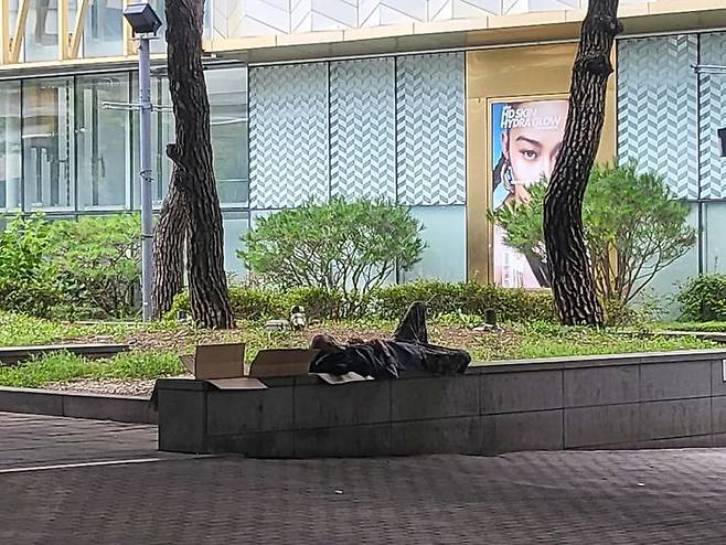 [수원=뉴시스] 최유리 인턴기자=수원역 롯데백화점 앞에서 노숙인이 벤치에 파지를 깔고 잠을 자고 있다. *재판매 및 DB 금지