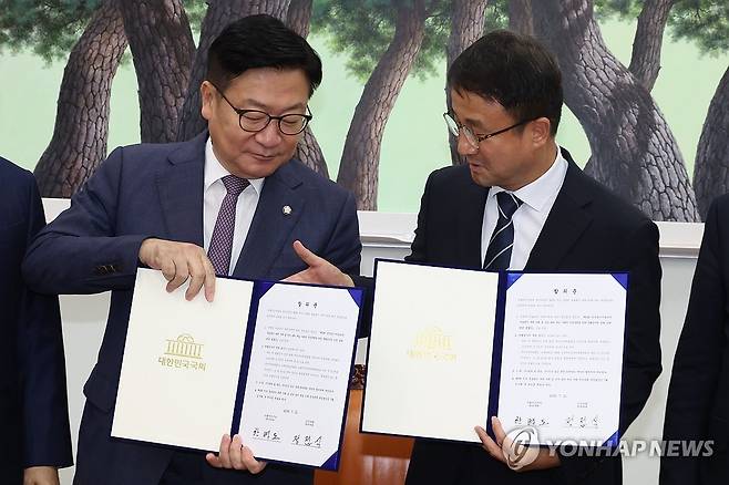 여야, 선관위 투표용지 부족 사태에 따른 특검 합의 (서울=연합뉴스) 배재만 기자 = 더불어민주당 한병도 대표 직무대행 겸 원내대표(오른쪽)와 국민의힘 정점식 원내대표가 21일 국회 운영위원장실에서 선관위 투표용지 부족 사태에 따른 특검법안 합의문에 서명한 뒤 기념 촬영을 하고 있다. 2026.7.21 [공동취재] scoop@yna.co.kr
