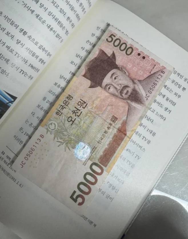 20대 여성 승객이 최근 택시기사에게 위로와 함께 받은 5000원짜리 지폐. 승객은 이 지폐를 쓰지 않고 아끼는 책에 보관 중이라며 감사함을 전했다. [스레드 캡처]
