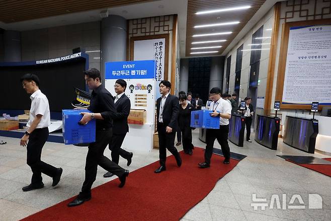 [서울=뉴시스] 조성우 기자 = 여고생 살인범 장윤기 사건을 둘러싼 부실수사와 유착 의혹을 수사 중인 검찰과 경찰이 경찰청 국가수사본부에 대한 강제수사에 나선 21일 서울 서대문구 경찰청에서 검찰 수사 관계자들이 압수수색을 마친 뒤 압수물품을 옮기고 있다. 2026.07.21. xconfind@newsis.com