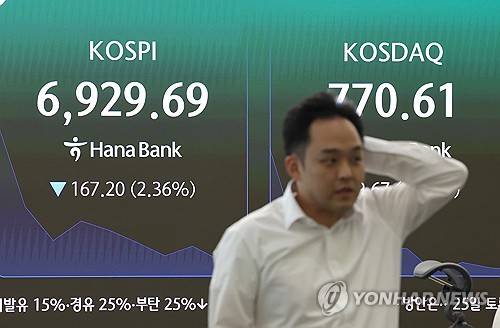 코스피 7천선 아래로 (서울=연합뉴스) 서명곤 기자 = 코스피가 하락 출발한 24일 서울 중구 하나은행 본점 딜링룸에서 한 딜러가 자리로 향하고 있다. 2026.7.24 seephoto@yna.co.kr
