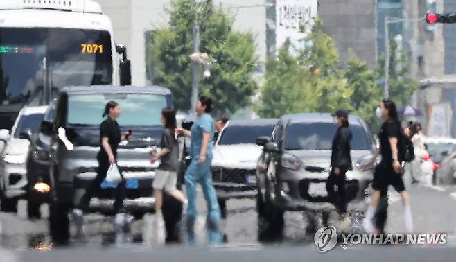 폭염 속 도로 건너는 시민 (울산=연합뉴스) 김용태 기자 = 절기상 가장 덥다는 대서(大暑)인 23일 울산에 이틀째 폭염경보가 발효 중인 가운데 남구 한 도로에 지열로 인한 아지랑이가 피어오르고 있다. 2026.7.23 yongtae@yna.co.kr