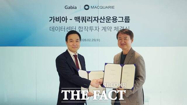 김용환(왼쪽) 맥쿼리자산운용그룹 한국지사 대표와 원종홍 가비아 공동대표가 계약 체결 후 악수를 하며 기념 촬영을 하고 있다. /가비아