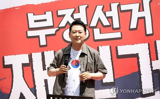 김해 집회 참석한 장동혁 대표 (김해=연합뉴스) 박영민 기자 = 국민의힘 장동혁 대표가 25일 오후 경남 김해시 내동 거북공원에서 열린 6·3 참정권 침해 규탄 김해시민 집회에서 연설하며 태극기가 그려진 옷을 보여주고 있다. 2026.7.25 ymp@yna.co.kr