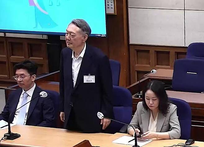 윤석열(가운데) 전 대통령이 13일 서울 서초구 서울중앙지법에서 열린 '명태균 여론조사 무상수수 의혹' 사건 1심 선고 공판 도중 일어나 선고 내용을 듣고 있다. 서울중앙지법 제공