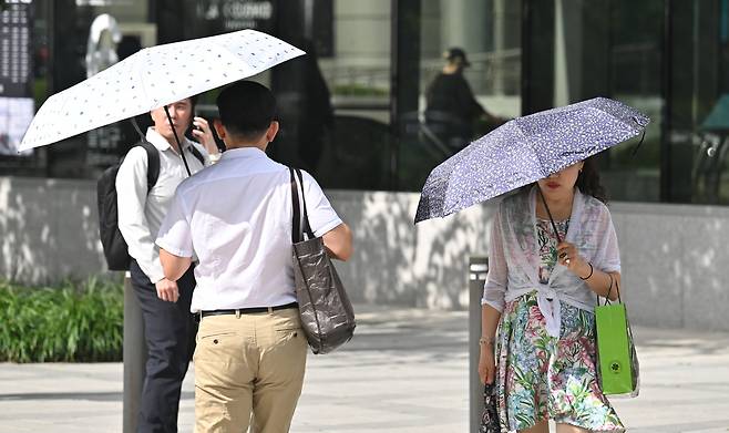 서울 종로구 세종대로 사거리에서 시민들이 우산으로 열기를 피하고 있다. 임세준 기자