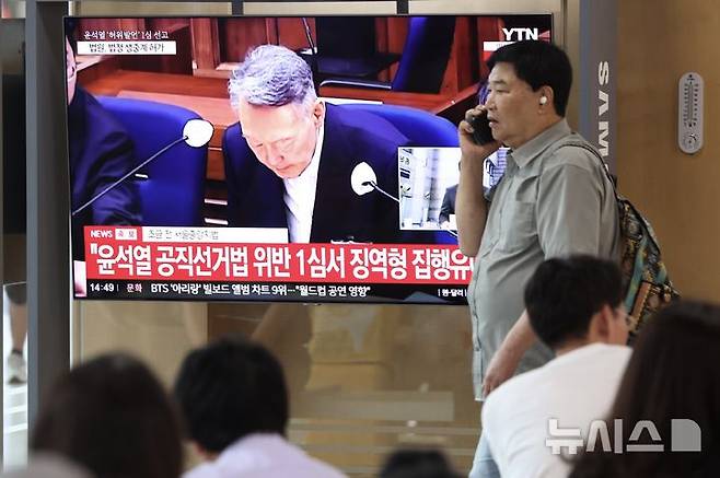 [서울=뉴시스] 김명년 기자 = 대선후보 시절 건진법사 전성배 씨에 관한 허위사실을 공표한 혐의로 기소된 윤석열 전 대통령 1심 선고 공판이 열린 27일 서울역에서 시민들이 관련 방송을 지켜보고 있다. 이날 재판부는 윤 전 대통령에게 징역 1년 6개월에 집행유예 3년을 선고했다. 2026.07.27. kmn@newsis.com