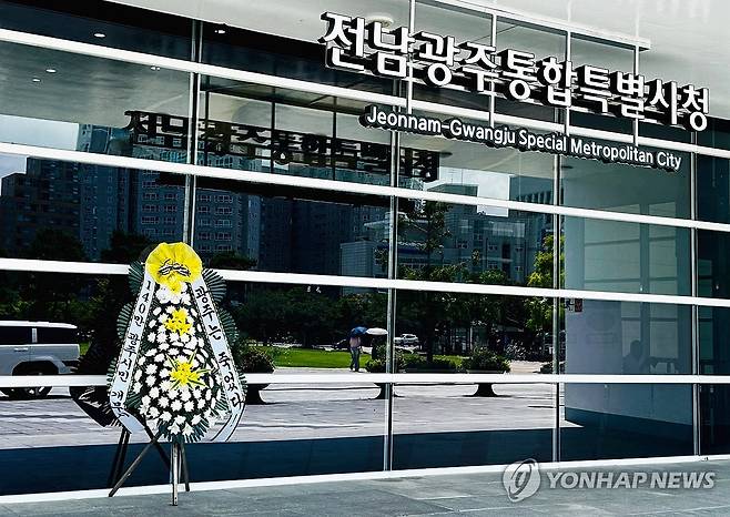 전남광주통합특별시 광주청사에 놓인 근조화환 (전남광주=연합뉴스) 장덕종 기자 = 24일 낮 전남광주 서구 전남광주통합특별시 광주청사 앞에 기획·예산·조직 등의 기관 유지 기능을 광주·무안·동부청사로 분산하는 조직개편에 반발하는 내용의 근조화환이 놓여있다. 2026.7.24 cbebop@yna.co.kr