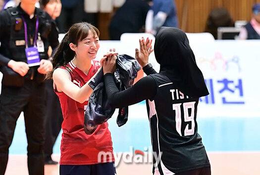 국가대표 세터 김다인이 인도네시아 선수와 기념촬영을 한 뒤 손을 맞잡고 밝게 인사를 하고 있다.