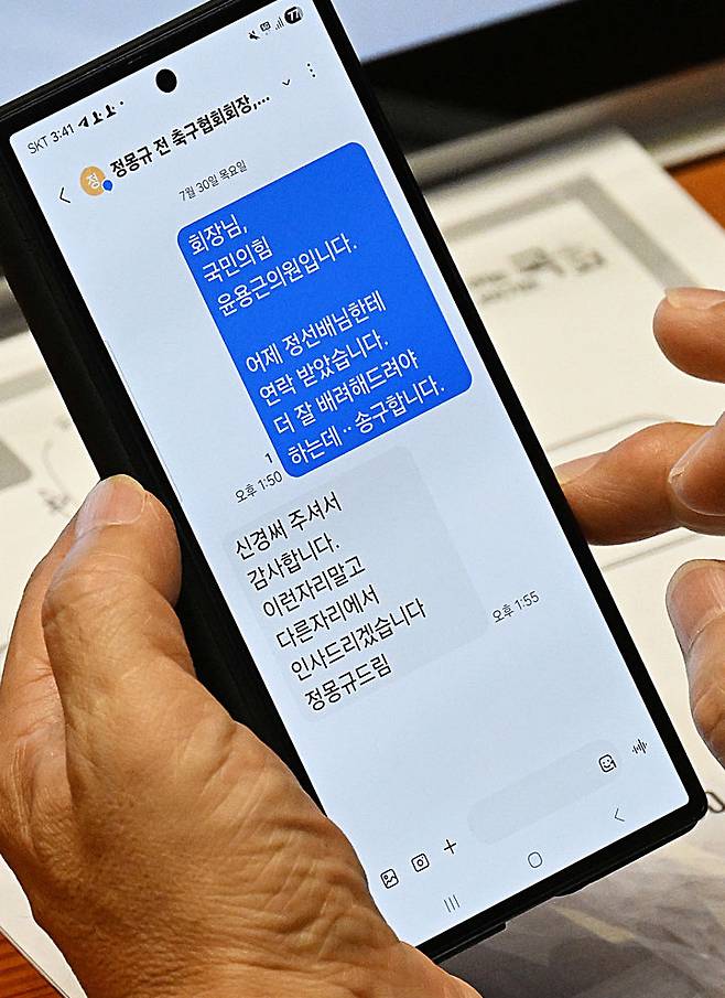 [서울=뉴시스]국회 문화체육관광위원회 소속 윤용근 국민의힘 의원이 30일 서울 여의도 국회 본회의장에서 대한축구협회 청문회 증인으로 출석한 정몽규 전 회장과 주고받 문자 메세지를 확인하고 있다. (사진=서울신문 제공) 2026.07.30. photo@newsis.com *재판매 및 DB 금지