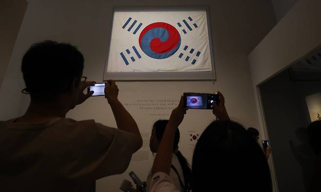 30일 재개관한 대한제국실에 전시된 '데니 태극기'를 관람객들이 휴대폰으로 촬영하고 있다. /장경식 기자