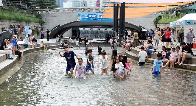 무더위가 지속되고 있는 31일 서울 종로구 청계천에서 진행된 "2026 청계천 첨벙첨벙"에 참가한 어린이들이 청계천에 들어가 더위를 식히고 있다.