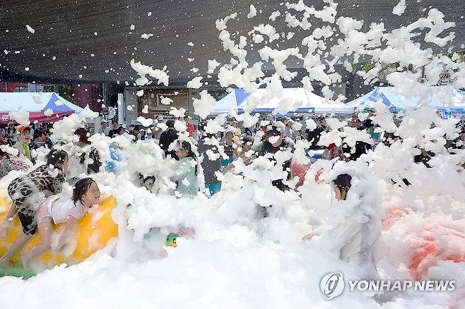 금남로에서 맞는 8월의 눈 (전남광주=연합뉴스) 민현기 기자 = 1일 오후 전남광주 동구 충장동에 마련된 길이 40m 규모의 대형 물놀이장에서 아이들이 인공눈을 맞고 있다. 2026.8.1 mhk0226@yna.co.kr