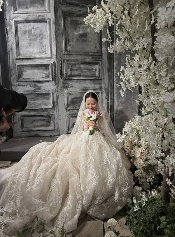 Actress Cho Yeo-jeong shared behind-the-scenes photos on her social media of herself dressed in a wedding dress and Hanbok with Kim Jae-chul during the filming of the Coupang Play series *Adultery Is Not the Issue Right Now*. Although they appear in the series as a former couple in the midst of a divorce lawsuit, the actual filming set displayed a warm and friendly atmosphere, revealing a contrasting charm.Cho Yeo-jeong perfectly recreated the look of a bride, posing affectionately with Kim Jae-chul while wearing a wedding dress and a traditional Korean hanbok for the Pyebaek ceremony. Scenes reminiscent of a real wedding, such as a kiss on the cheek directed at Kim Jae-chul, particularly caught the eye.In the series, Cho Yeo-jeong plays the role of Su-jeong, a dermatologist, while Kim Jae-chul plays the role of her ex-husband, Bo-seong, portraying a conflicting relationship engaged in a messy divorce lawsuit. Cho Yeo-jeong mentioned that they live as a loving couple off-camera, conveying the atmosphere on set that contrasted sharply with their on-screen relationship.Adultery Is Not the Issue is a black comedy drama about a popular influencer couple and a doctor couple who become entangled in a huge secret. Starring Kim Hye-soo, Cho Yeo-jeong, Kim Ji-hoon, and Kim Jae-chul, it was released on Coupang Play on July 31.