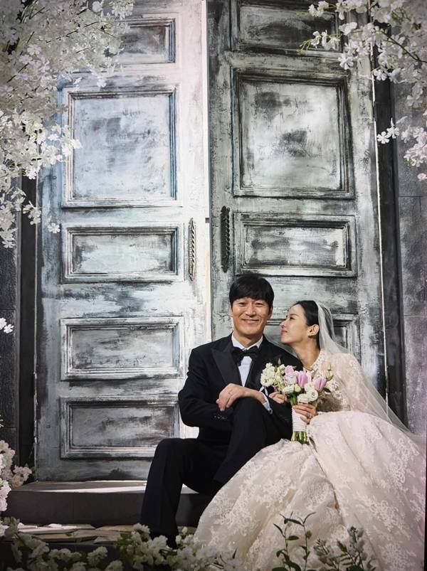 Actress Cho Yeo-jeong shared behind-the-scenes photos on her social media of herself dressed in a wedding dress and Hanbok with Kim Jae-chul during the filming of the Coupang Play series *Adultery Is Not the Issue Right Now*. Although they appear in the series as a former couple in the midst of a divorce lawsuit, the actual filming set displayed a warm and friendly atmosphere, revealing a contrasting charm.Cho Yeo-jeong perfectly recreated the look of a bride, posing affectionately with Kim Jae-chul while wearing a wedding dress and a traditional Korean hanbok for the Pyebaek ceremony. Scenes reminiscent of a real wedding, such as a kiss on the cheek directed at Kim Jae-chul, particularly caught the eye.In the series, Cho Yeo-jeong plays the role of Su-jeong, a dermatologist, while Kim Jae-chul plays the role of her ex-husband, Bo-seong, portraying a conflicting relationship engaged in a messy divorce lawsuit. Cho Yeo-jeong mentioned that they live as a loving couple off-camera, conveying the atmosphere on set that contrasted sharply with their on-screen relationship.Adultery Is Not the Issue is a black comedy drama about a popular influencer couple and a doctor couple who become entangled in a huge secret. Starring Kim Hye-soo, Cho Yeo-jeong, Kim Ji-hoon, and Kim Jae-chul, it was released on Coupang Play on July 31.